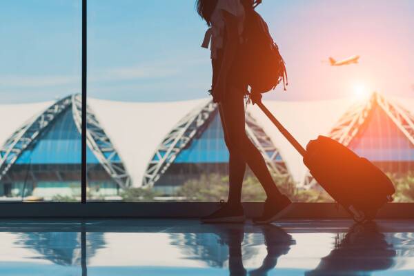 Silhouette,Woman,Travel,With,Luggage,Walking,Side,Window,At,Airport